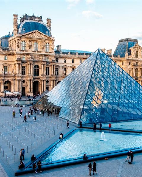 Piazza di un museo con la piramide di vetro all'ingresso