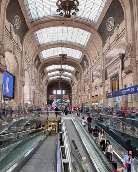 Atrio di una grande stazione ferroviaria con passeggeri