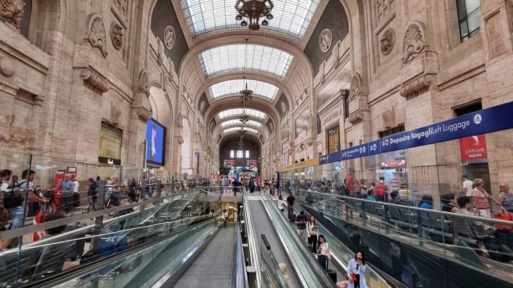 Interno di una stazione ferroviaria con passeggeri in transito